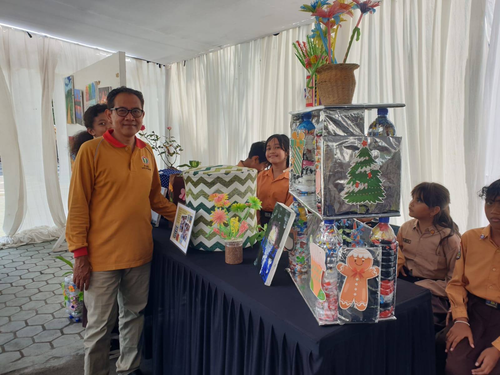 KREATIF: Plt Kepala SDN 2 Cakranegara Ahmadiyah melihat karya P5 muridnya di halaman sekolah setempat, Sabtu (23/11) lalu. IST/LOMBOK POST