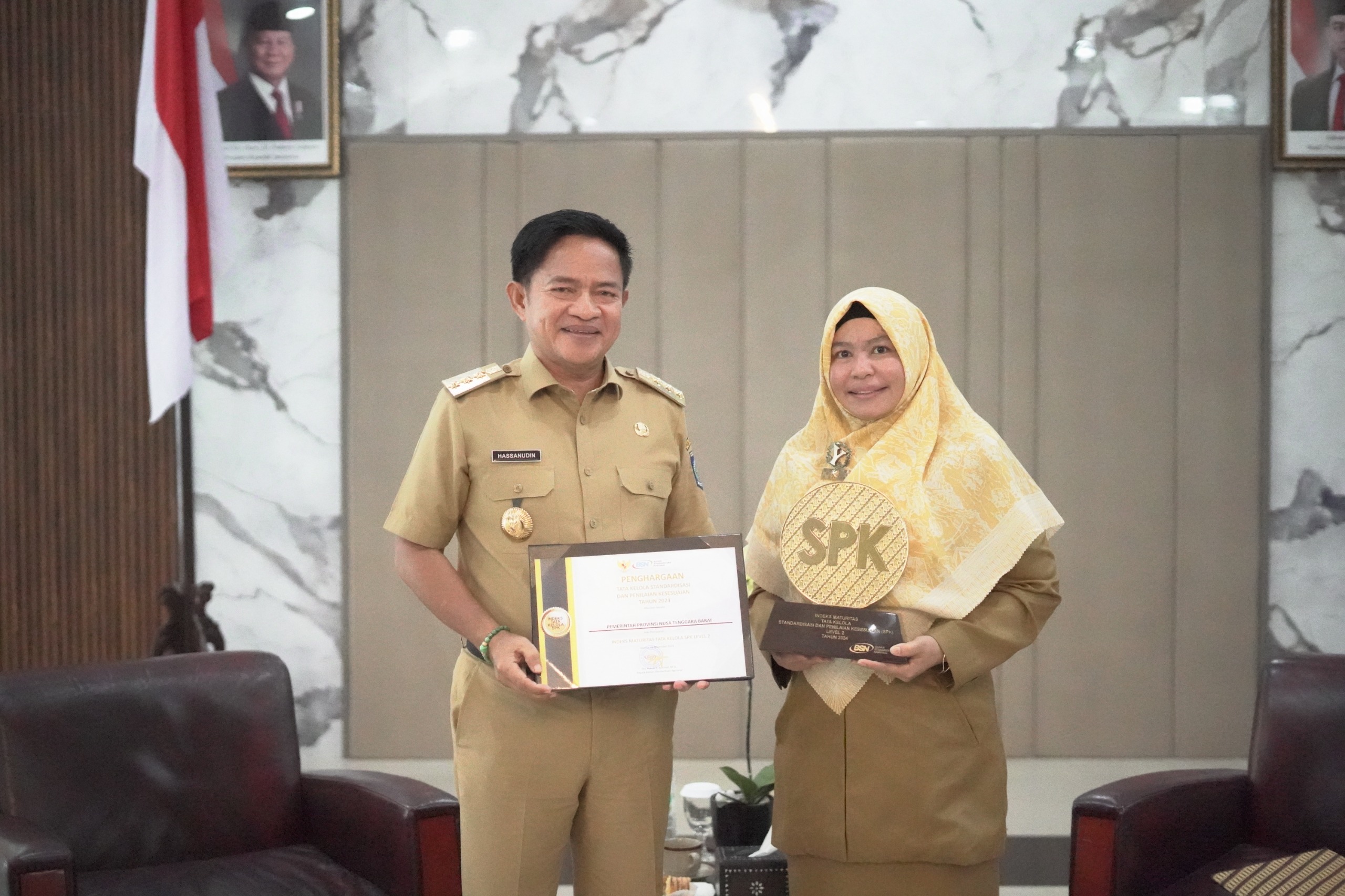 TERIMA PENGHARGAAN: Pj Gubernur NTB  Hassanudin dan Kepala Disperin NTB Hj Nuryanti menunjukkan penghargaan dari Badan Standarisasi Nasional (BSN), Selasa (26/11)