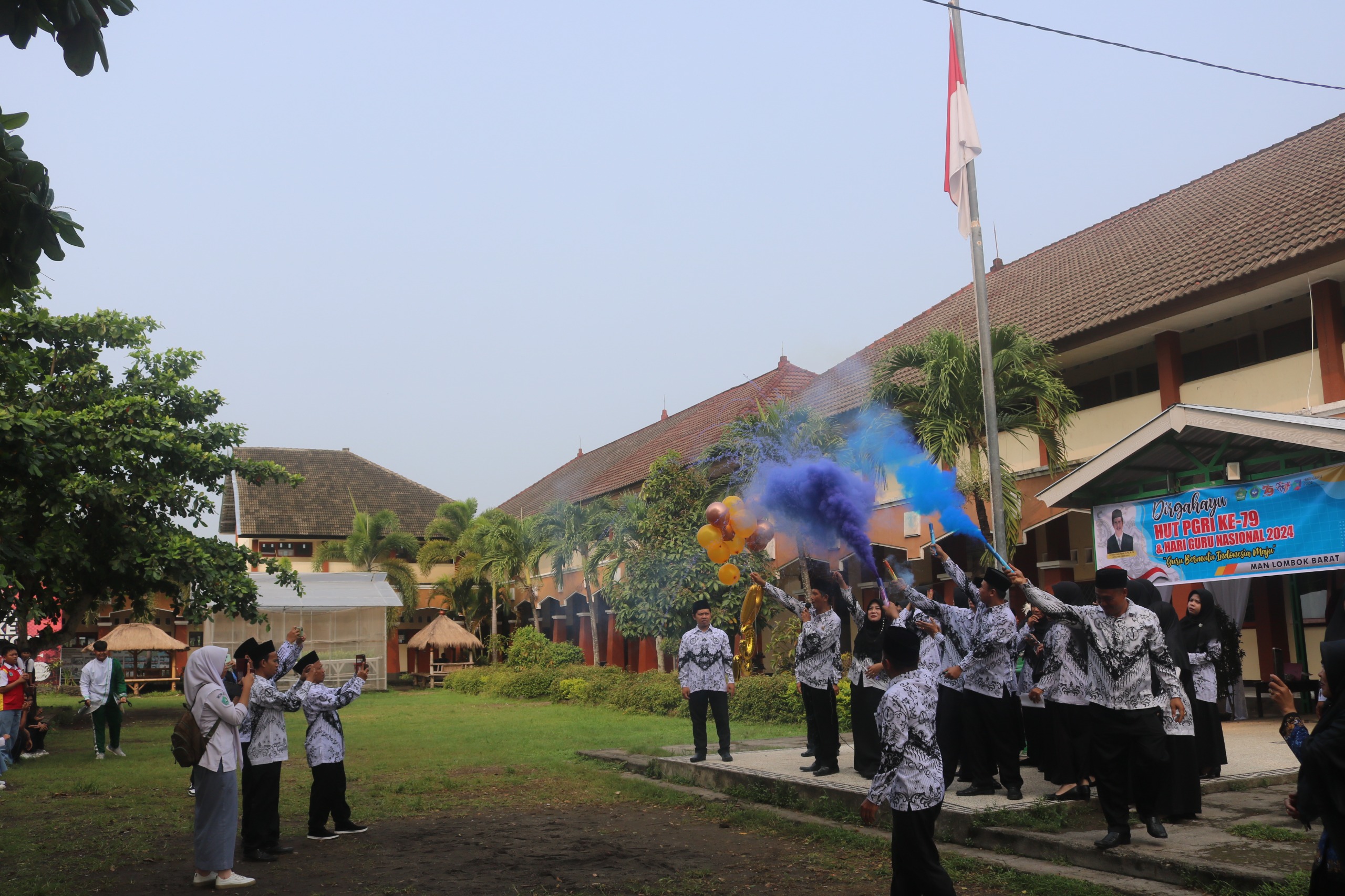MERIAH: Guru MAN Lobar membakar flare memeriahkan HGN 2024 di madrasah setempat, Senin (25/11). MAN LOBAR FOR LOMBOK POST