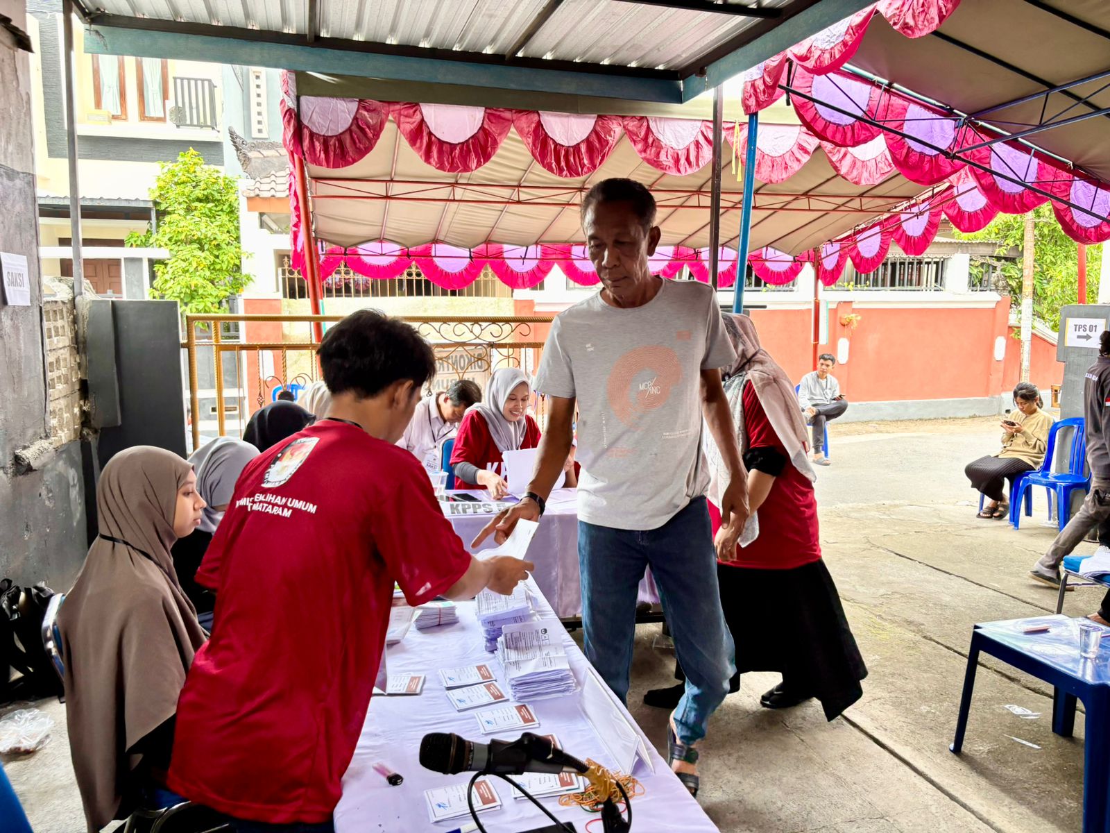 PESTA DEMOKRASI: Seorang warga mengambil surat suara di petugas KPPS untuk mencoblos para calon kepala daerah, pada Pilkada serentak 2024, di TPS 001 Lingkungan Pusaka, Mataram, Rabu (27/11). 