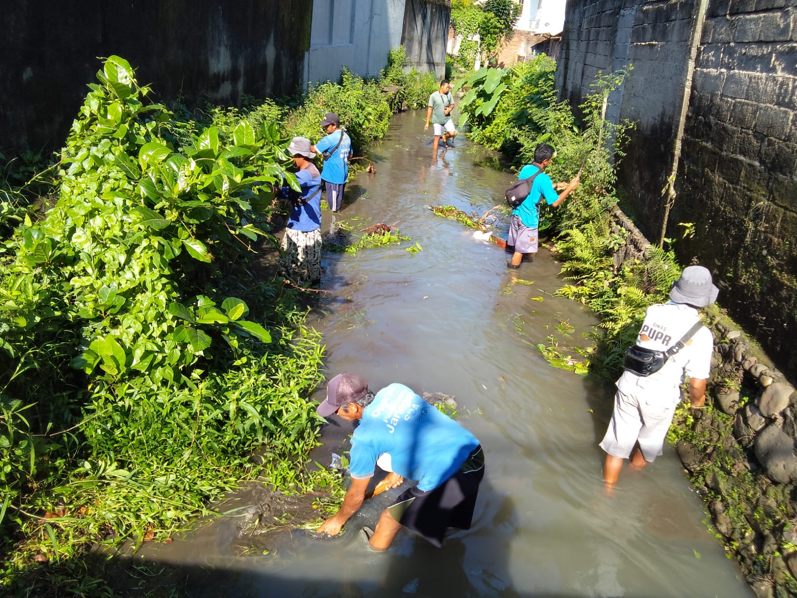BIANG GENANGAN: Petugas membersihkan ruas saluran di Geguntur dari semak belukar, belum lama ini. ZAD/LOMBOK POST