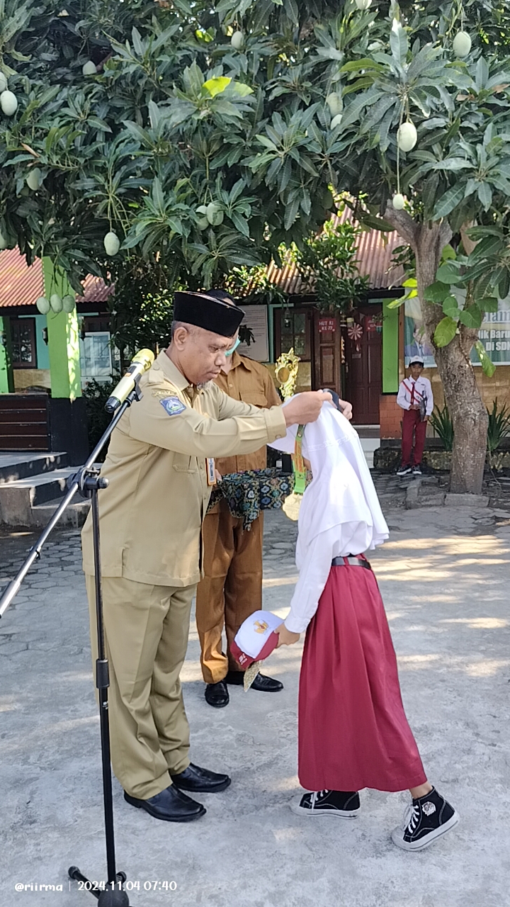 BERPRESTASI: Kepala SDN 47 Mataram Zainuddin memberikan penghargaan kepada murid berprestasi pada saat apel di sekolah setempat, belum lama ini.