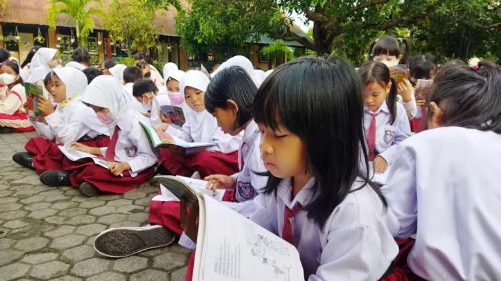 DAPAT MAKAN BERGIZI GRATIS: Sejumlah siswa duduk saat belajar di tempat terbuka di sekolahnya, beberapa waktu lalu.