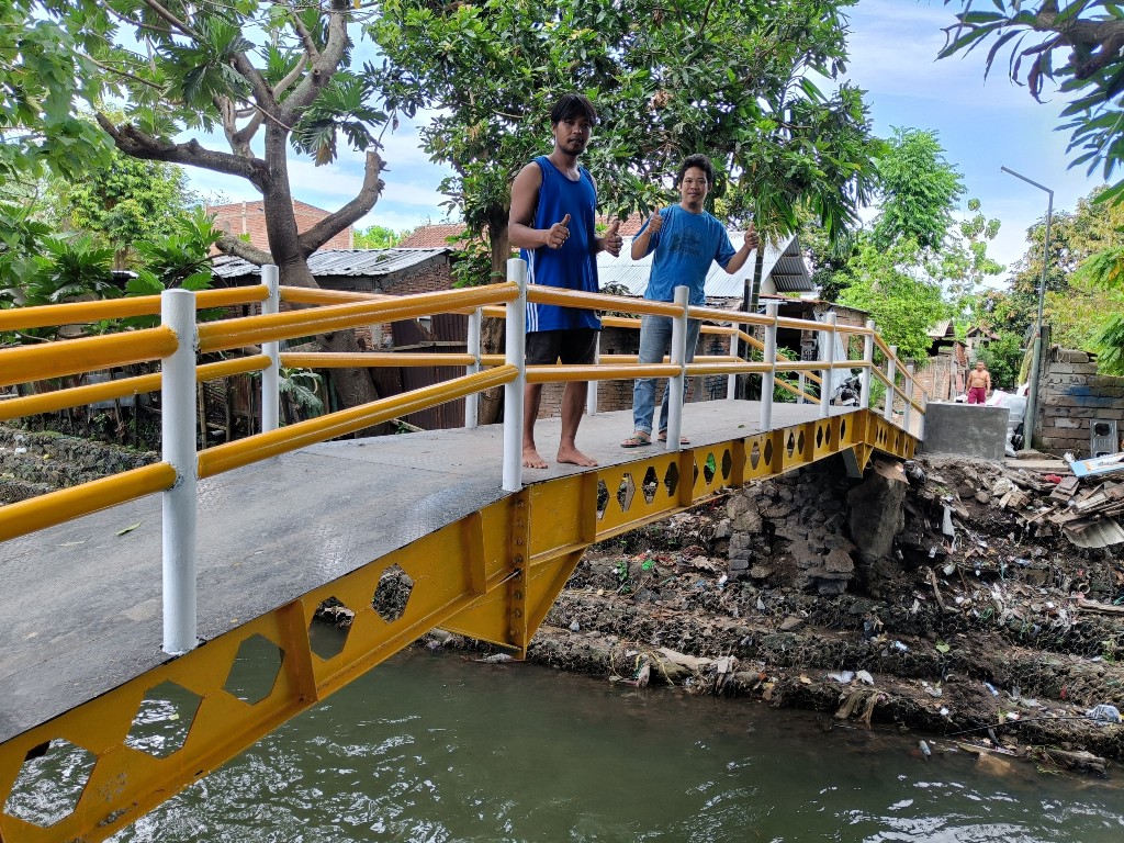 KOKOH DAN AMAN: Sahab (celana pendek) dan Adi (celana panjang) memberikan jempol untuk pengerjaan jembatan Remora, Kelurahan Taman Sari, Kecamatan Ampenan, Kota Mataram, Selasa (3/12)