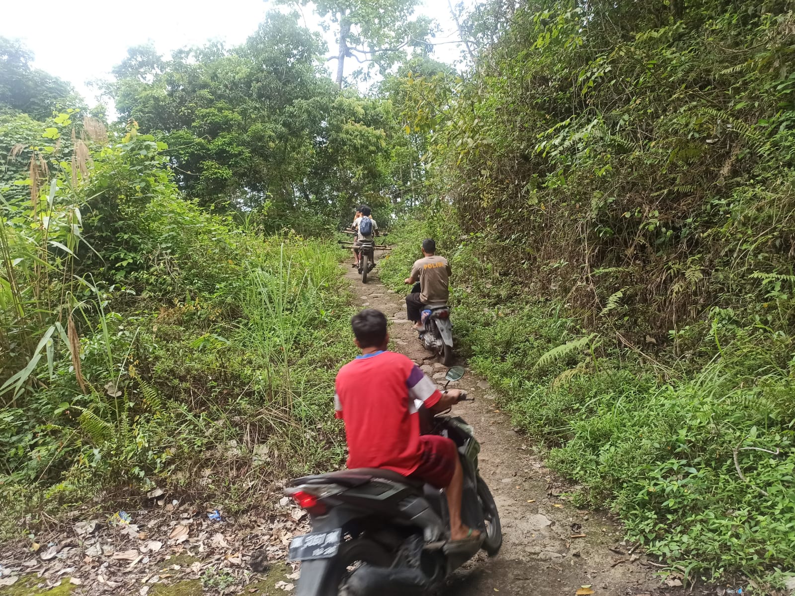 TERPENCIL: Warga RT 03 Sela Golong, Dusun Lelongken, Desa Sajang, Kecamatan Sembalun, Lombok Timur melintasi jalan setapak, yang merupakan satu-satunya akses masuk dan keluar masyarakat.