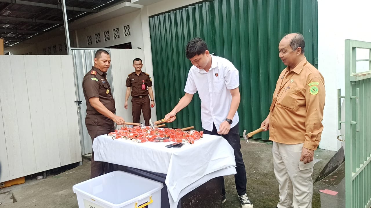 MUSNAHKAN: Kepala Kejaksaan Negeri Lombok Timur bersama Kasat Narkoba Polres Lotim saat memusnahkan sejumlah barang bukti dari 63 perkara di Kantor Kejari Lotim, Rabu (4/12).