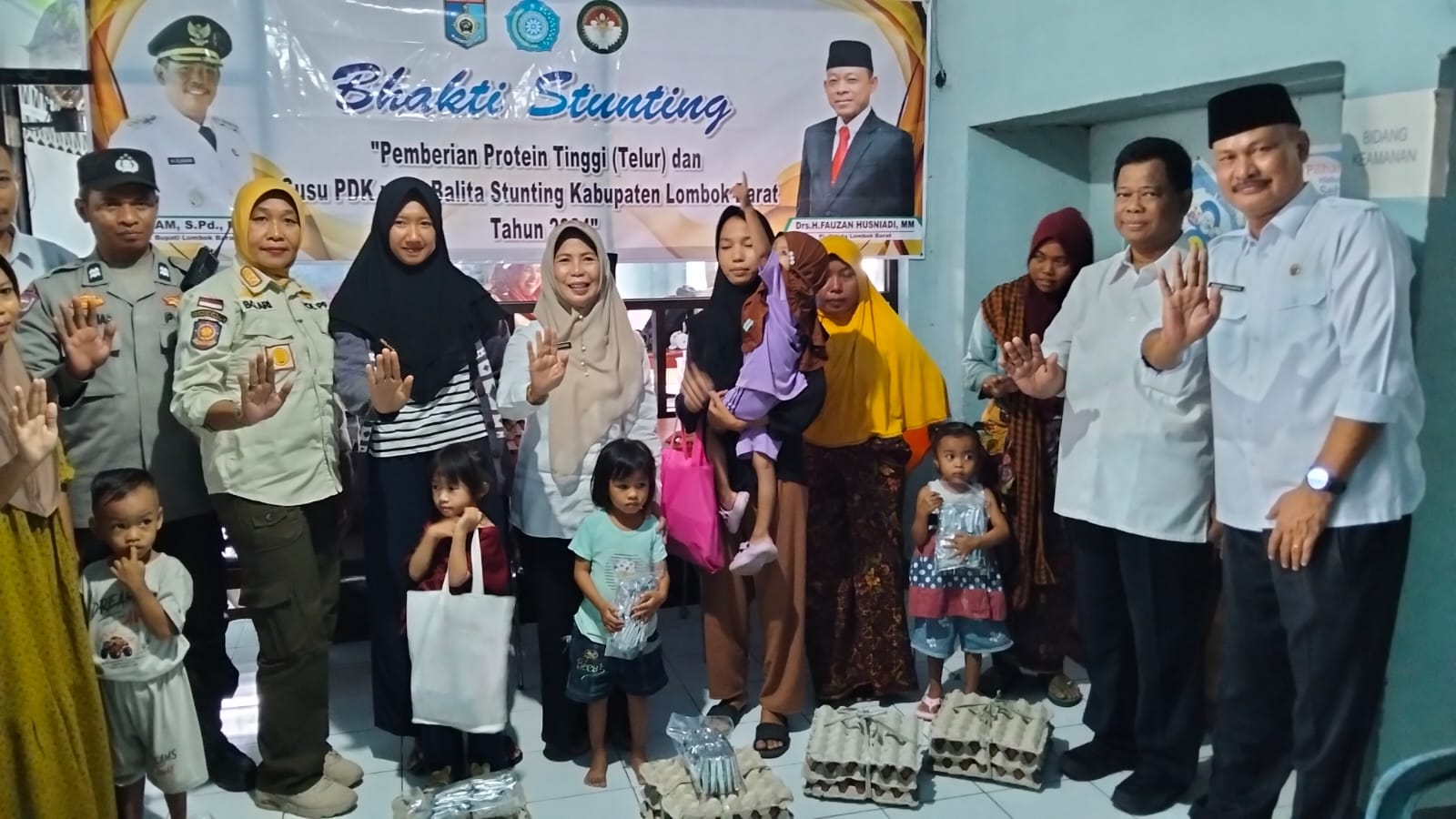 CEGAH STUNTING: Ketua Tim Penggerak (TP) PKK Lobar Erni Zuhara Ilham (kanan) dampingi Kadis Kominfotik Ahad Legiarto (dua dari kanan) membagikan telur dan susu sachet ke warga di Desa Kebon Ayu.