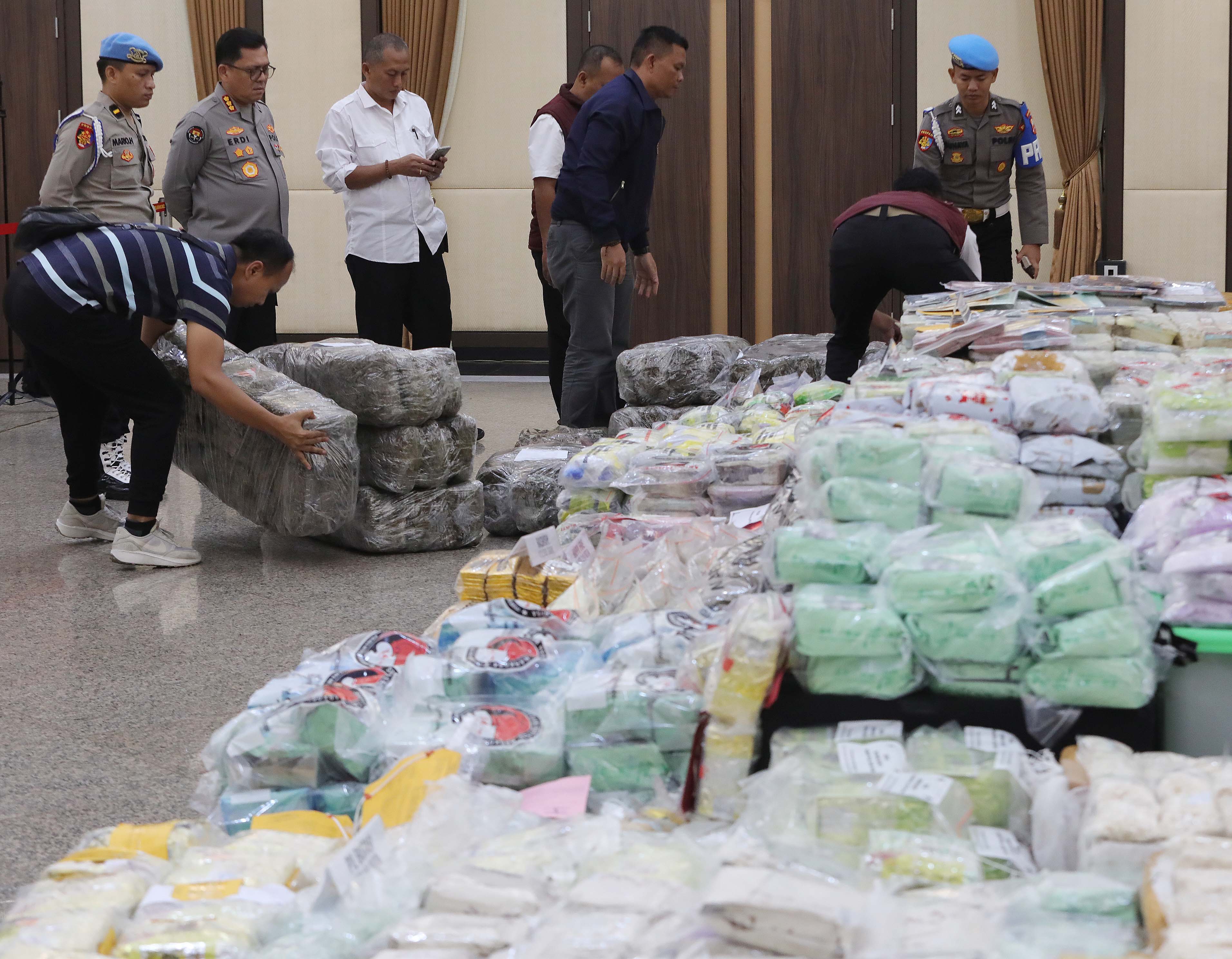 Petugas membawa barang bukti narkoba saat press release terkait Pencapaian Desk Pemberantasan Narkoba di Mabes Polri, Jakarta, Kamis (5/12/2024). Dalam satu bulan terakhir, Desk Pemberantasan Narkoba yang dibentuk oleh Polri menangani 3.680 perkara narkob