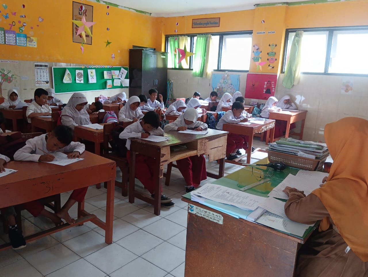 KERJAKAN SOAL: Murid SDN 33 Mataram melaksanakan PAS di sekolah setempat, Senin (9/12).