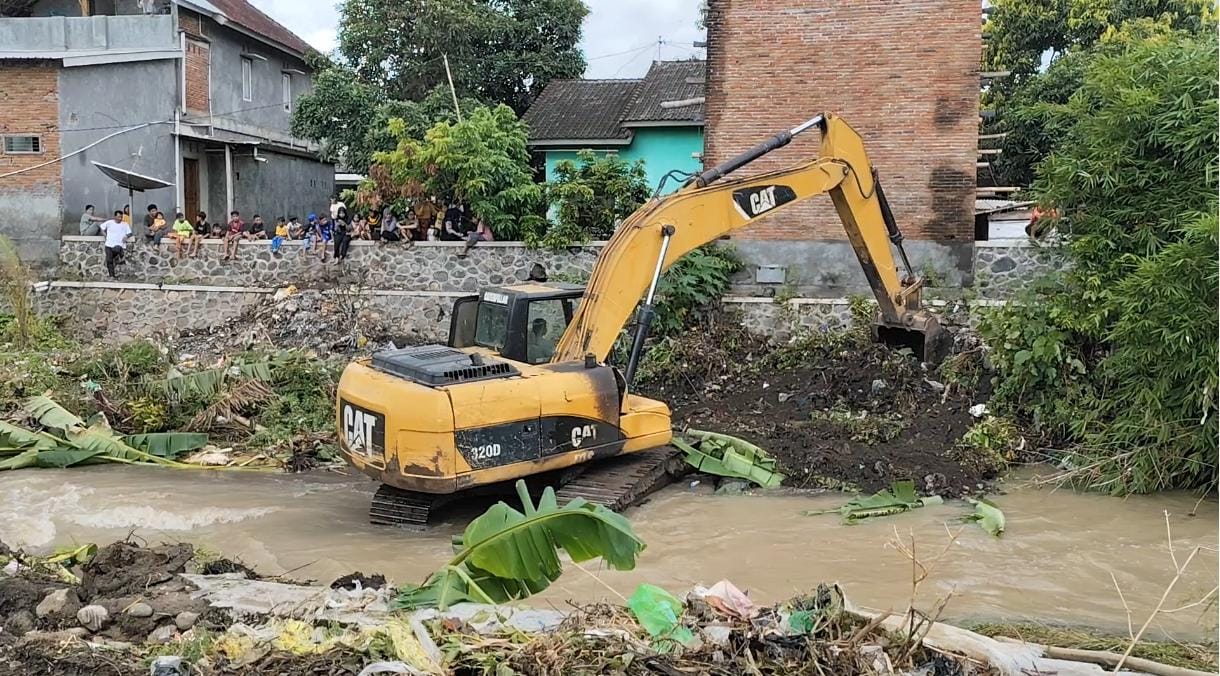 KERUK: Sebuah alat berat dikerahkan Pemkab Lotim untuk mengeruk sedimentasi di Sungai Orong Bukal yang sempat meluap akibat intensitas hujan yang cukup tinggi, Rabu (11/12).