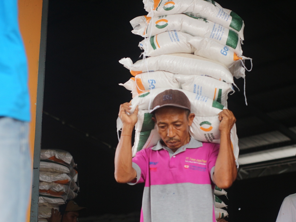 BERAS BANTUAN: Seorang buruh mengangkut beras bantuan pangan Cadangan Pangan Pemerintah di gudang Bulog Lotim, Kamis (12/12).