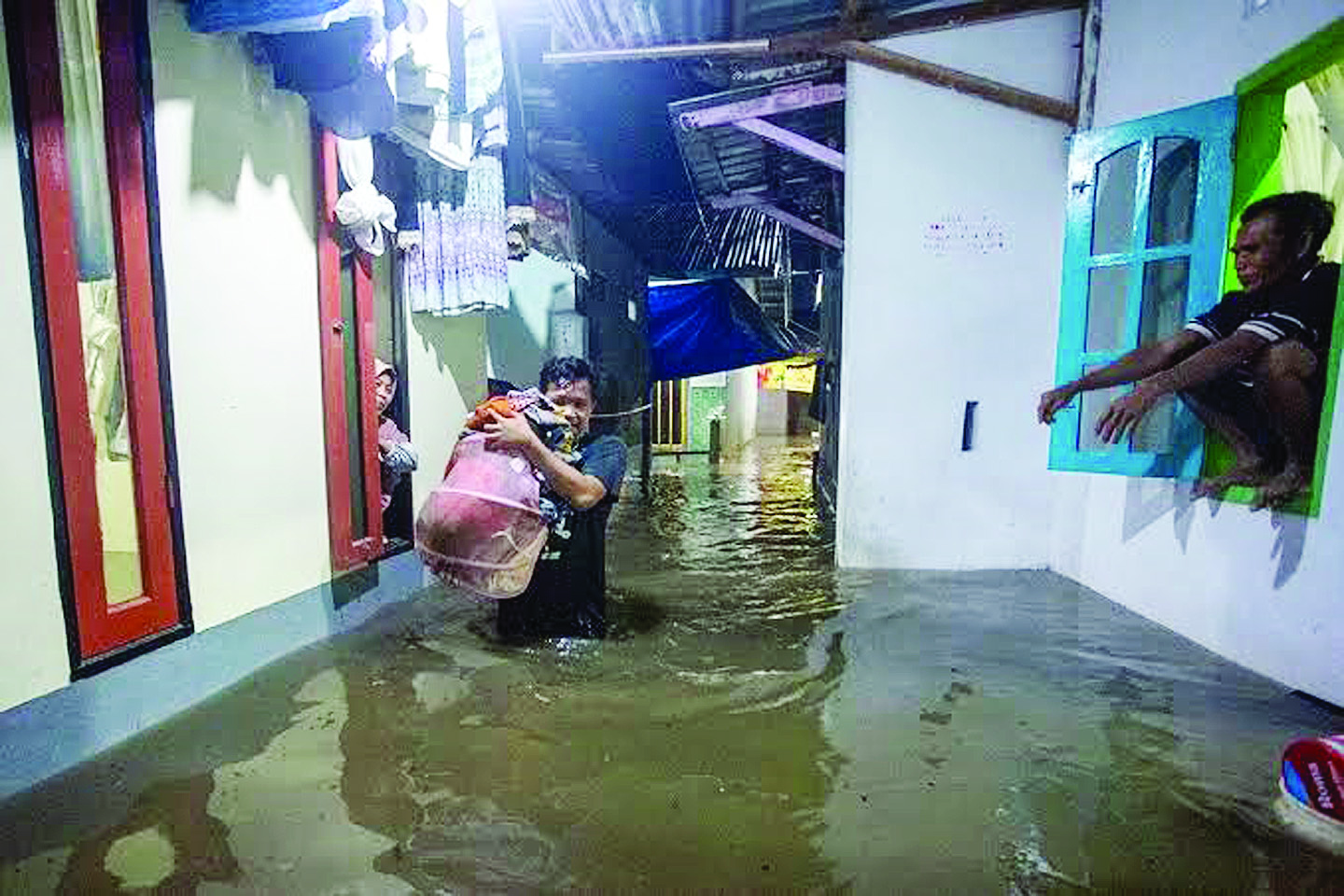 TIDAK PERLU RESAH: Seorang warga Kota Mataram membopong barangnya saat terjadi banjir di kawasan Sekarbela, Mataram, beberapa waktu lalu.