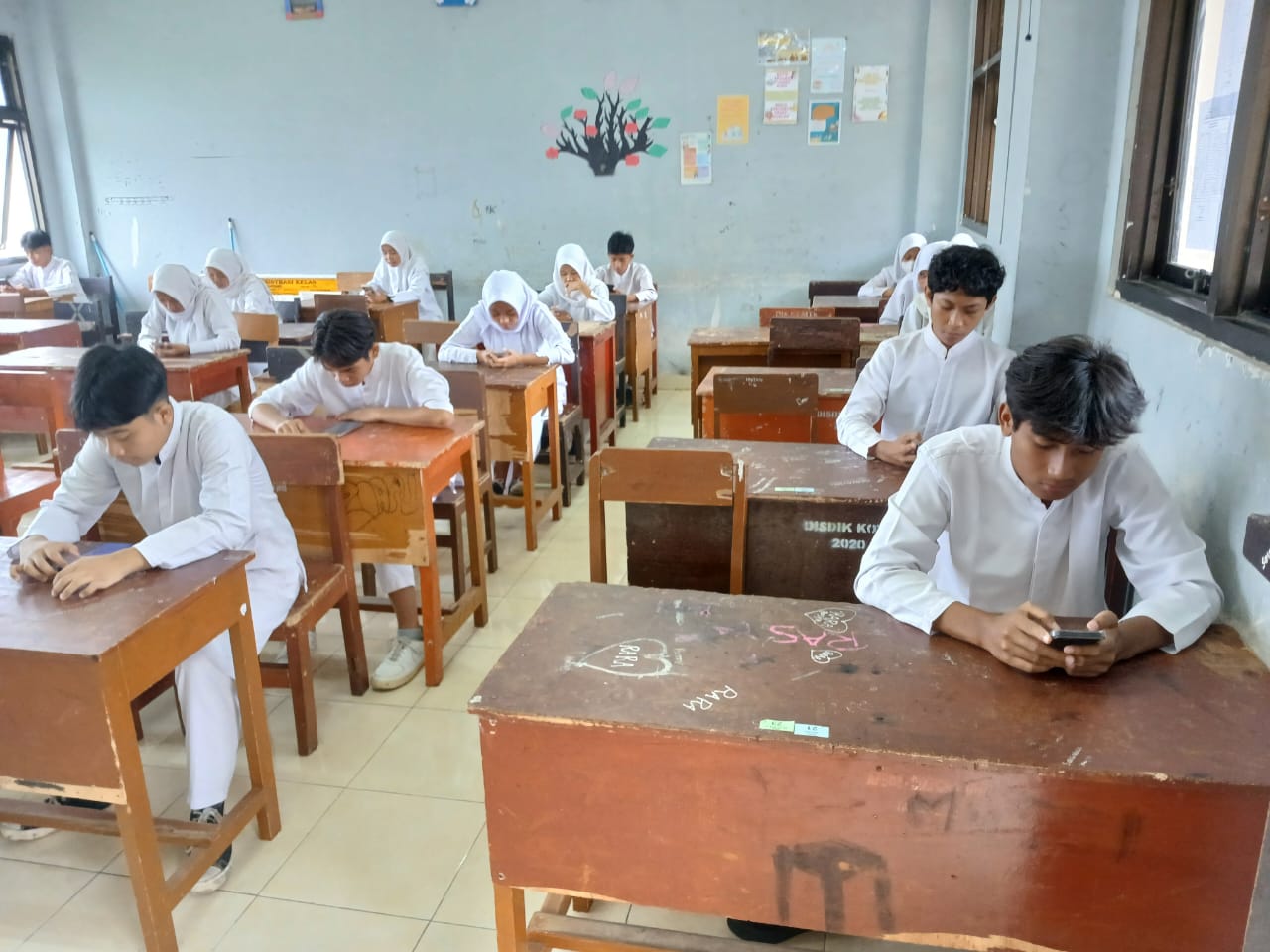 KERJAKAN SOAL: Siswa SMPN 6 Mataram melaksanakan ujian semester ganjil menggunakan android di sekolah setempat, Jumat (13/12).