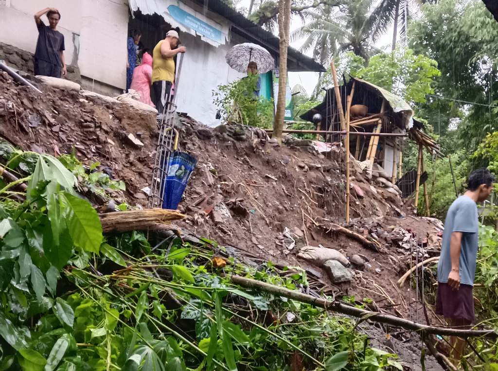 BENCANA ALAM: Warga dan petugas BPBD Lobar gotong royong membersihkan rumah warga di lokasi longsor di Dusun Medas Baru, Desa Tamansari, Gunungsari, Selasa (17/12).