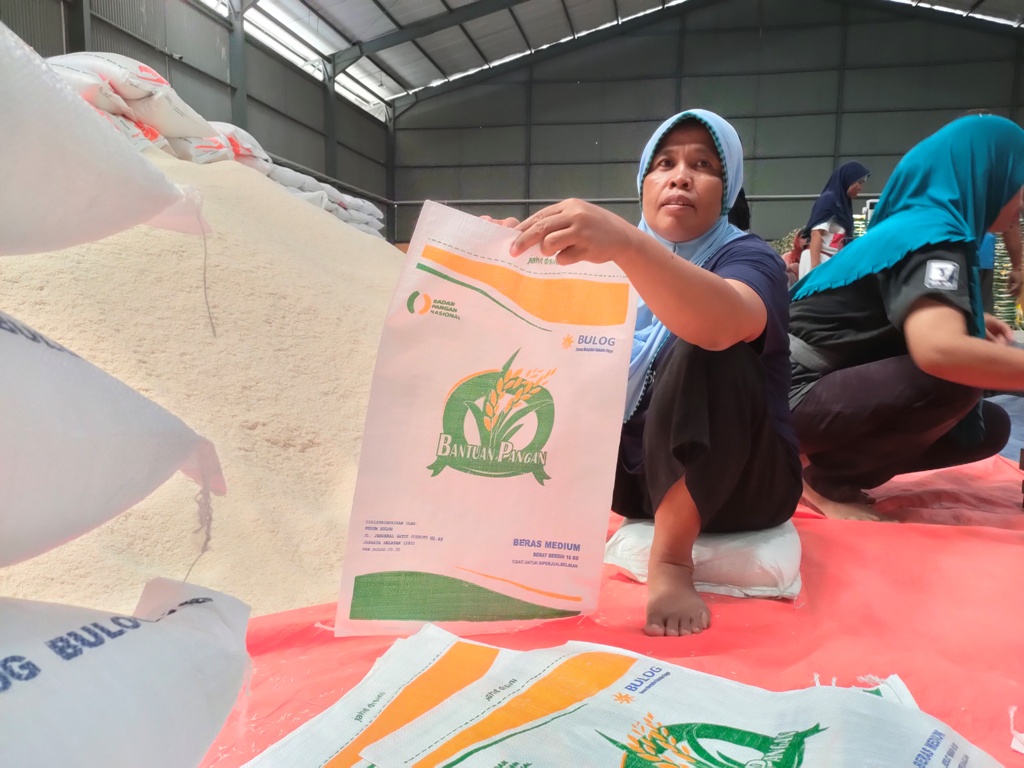 SUDAH SIAP DISALURKAN: Petugas dari Bulog memasukkan beras CPP ke dalam karung untuk disalurkan ke masyarakat di Gudang Bulog Dasan Cermen, Mataram, beberapa waktu lalu.