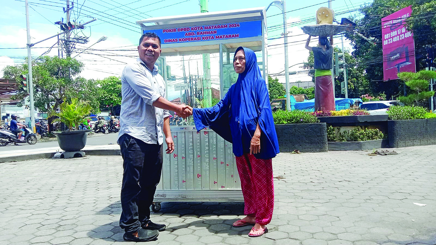 SENYUM: Ketua Komisi 3 DPRD Kota Mataram Abd Rahman menyalurkan gerobak dorong Diskoperin UKM ke warga, Selasa (17/12).