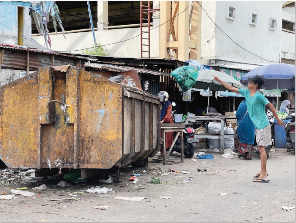 LELUASA: Seorang warga membuang sampah ke dalam kontainer sampah di pasar Kebon Roek, Jumat (20/12).