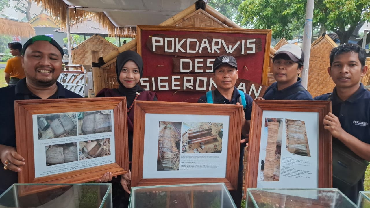 WARISAN LELUHUR: Muhamadun (paling tengah) bersama anggota Pokdarwis Desa Sigerongan, Kecamatan Lingsar, menunjukkan manuskrip kuno berupa Alquran 30 juz dan materi khotbah Idul Fitri dari kulit unta.