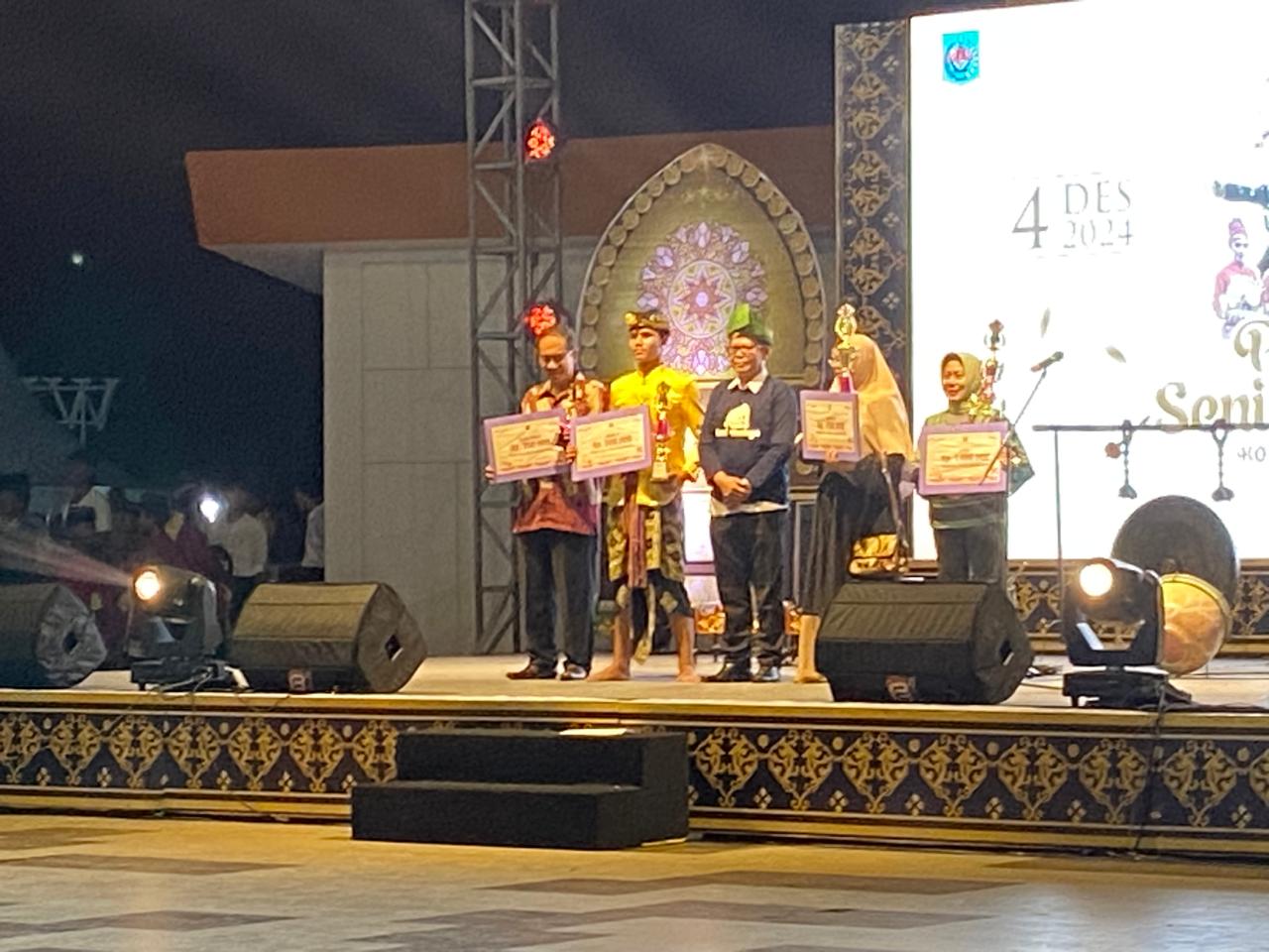 JUARA: Siswa SMPN 14 Mataram (dua dari kiri) menerima piala dan penghargaan pada lomba gendang beleq pada pentas seni budaya di Teras Udayana, belum lama ini.