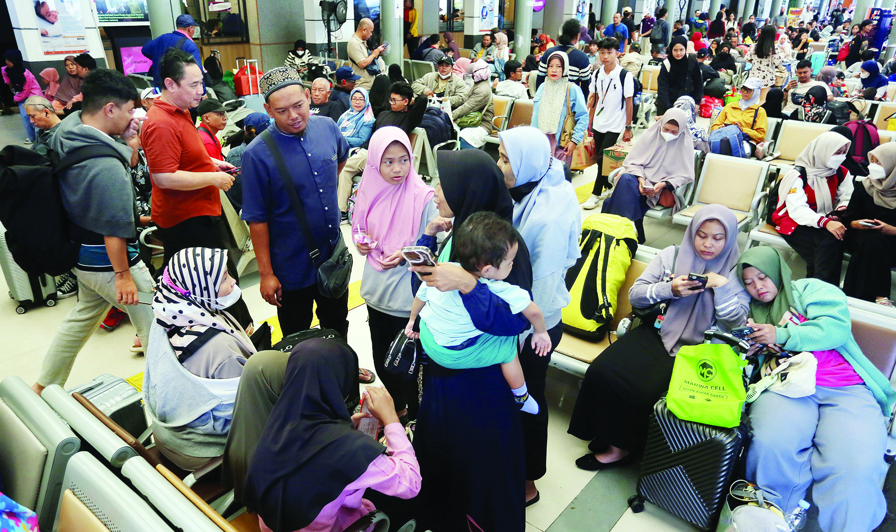 Calon penumpang menunggu kedatangan kereta api Dharmawangsa dan Gaya Baru Malam jurusan Surabaya, Serayu Purwokerto, Kutojaya Utara Kutoarjo serta Tawang Jaya jurusan Semarang di ruang tunggu Stasiun Pasar Senen Jakarta, Minggu (22/12/2024). PT KAI (Perse