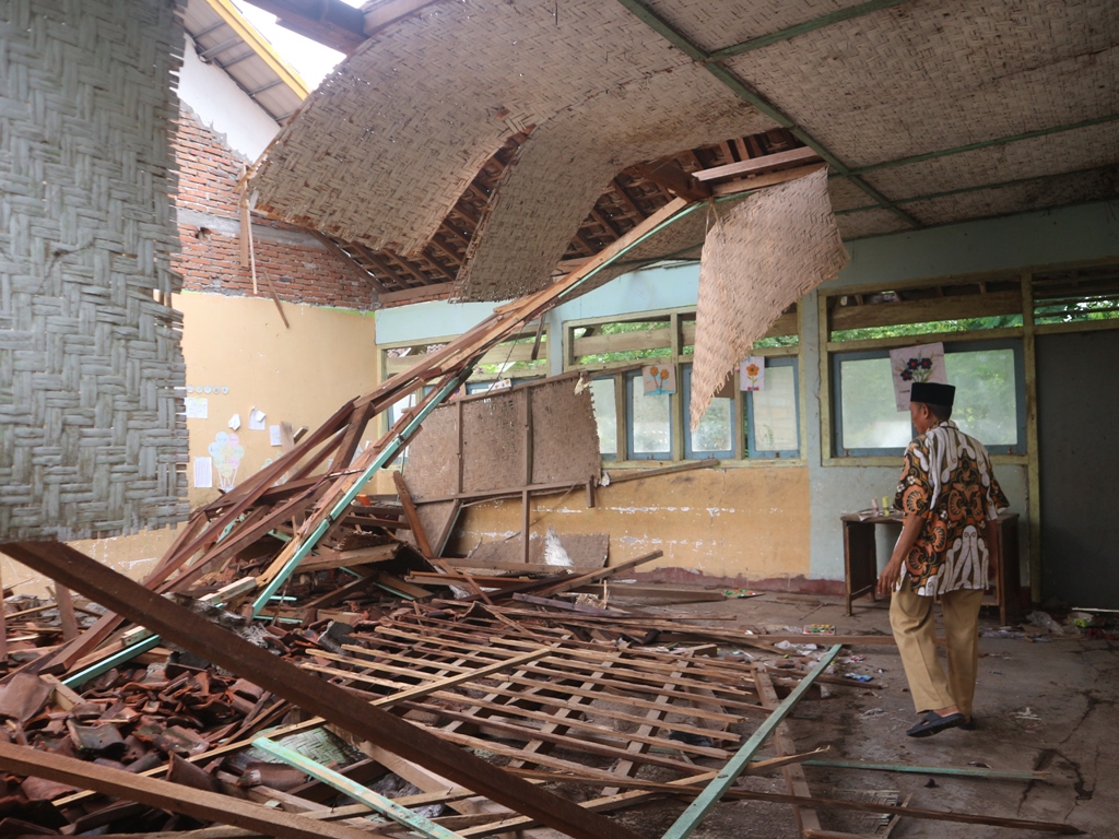 CEK KERUSAKAN: Muhammad Nasir Kepala Sekolah SDN 5 Jerowaru mengecek kondisi ruangan belajar yang rusak akibat hujan deras disertai angin kencang yang terjadi pada Selasa malam (24/12) lalu.