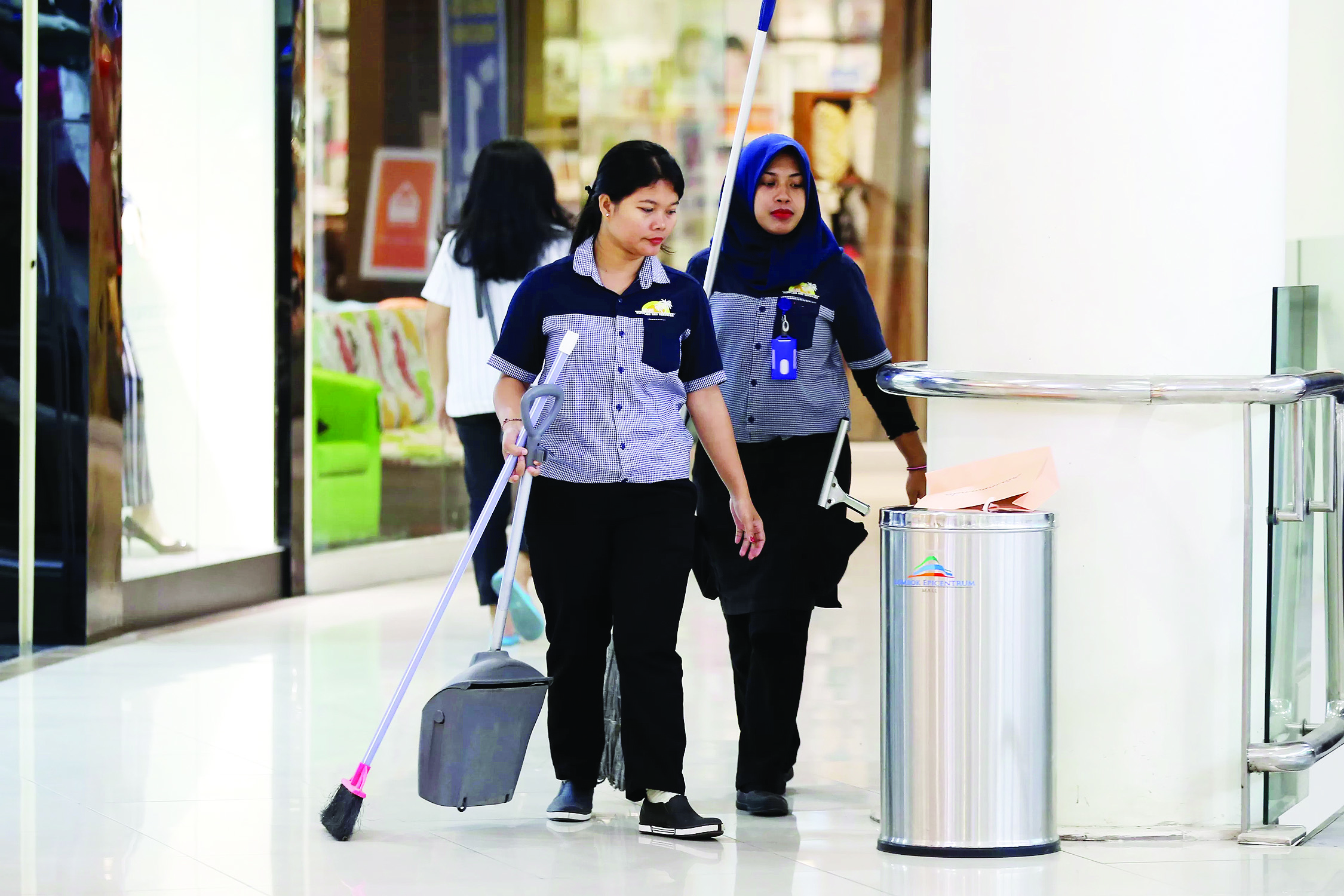HARUS DAPATKAN UPAH SESUAI UMK: Seorang pegawai kebersihan di Lombok Epicentrum Mall bercengkrama dengan rekan kerjanya, beberapa waktu lalu.