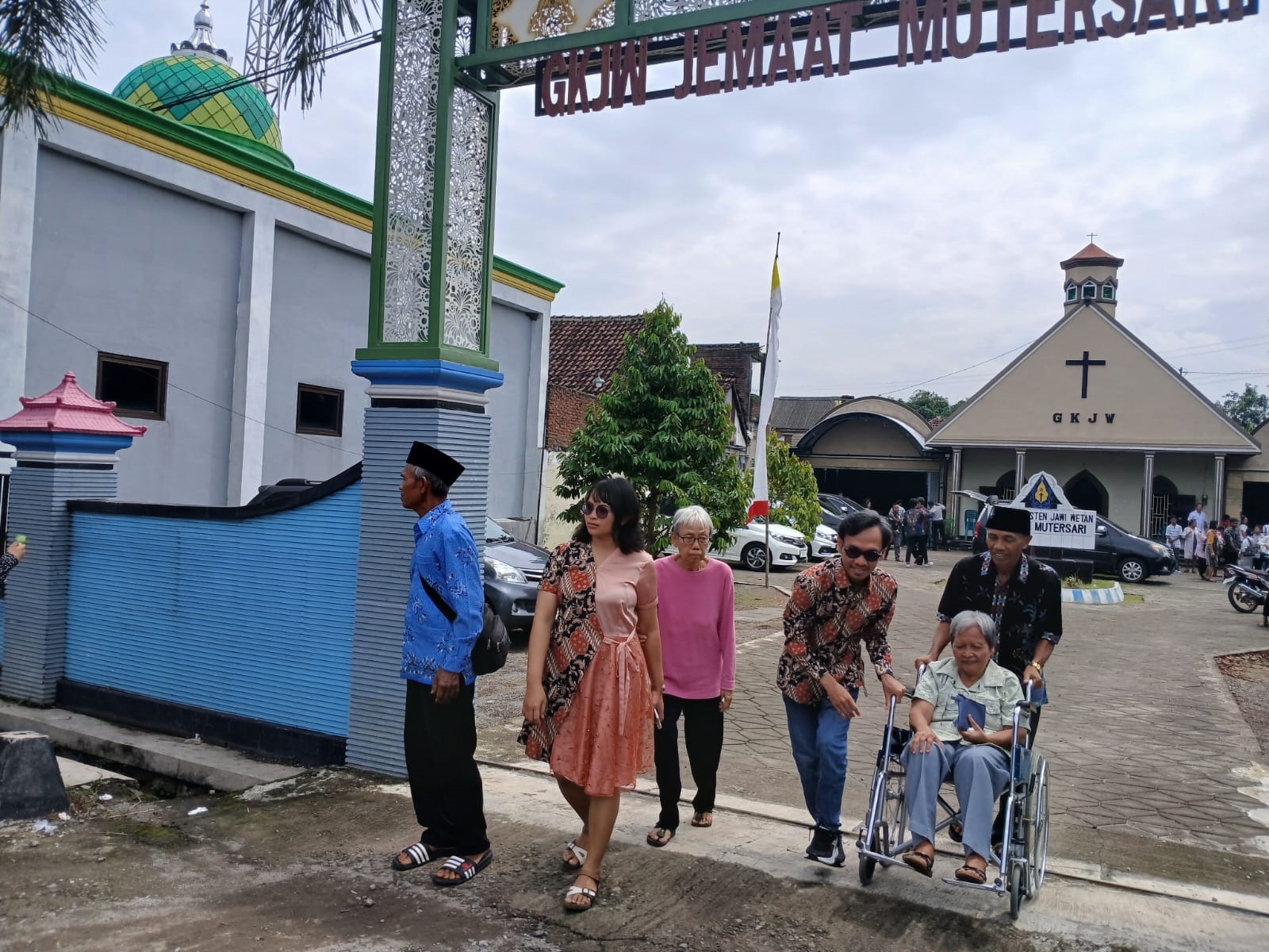 RUKUN BERDAMPINGAN: Warga Dusun Mutersari, Jombang berjalan keluar kompleks tempat Masjid Al-Hidayah dan GKJW Mutersari berdiri bersebelahan.