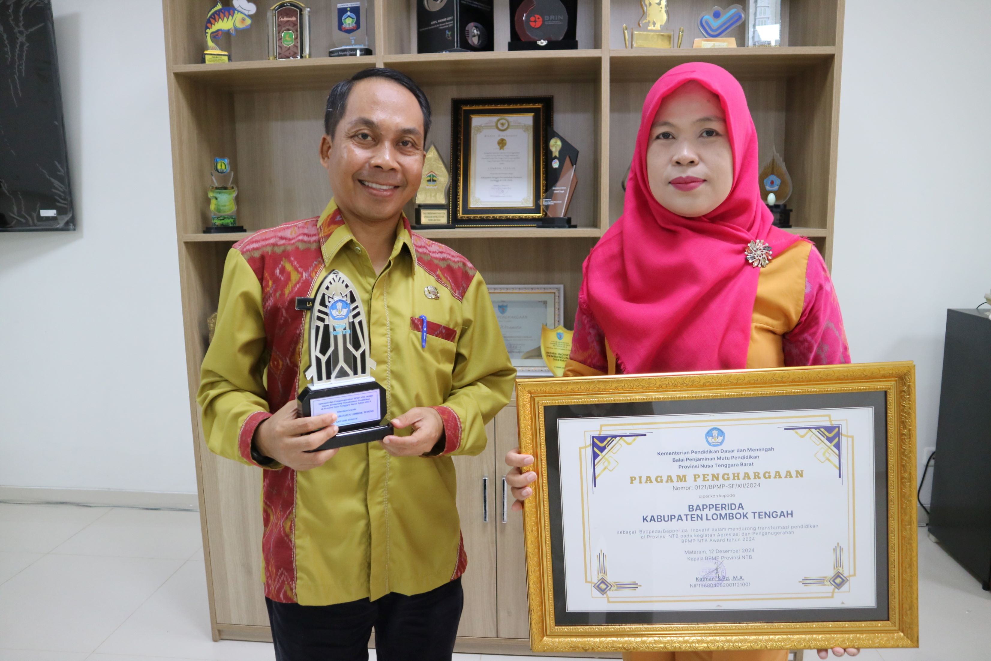 Kepala Bapperida Loteng Lalu Wiranata (kiri) berfoto bersama Kepala Bidang P2M Bapperida Loteng Sri Muliana Widiastuti (kanan) raih penghargaan dari BPMP NTB.