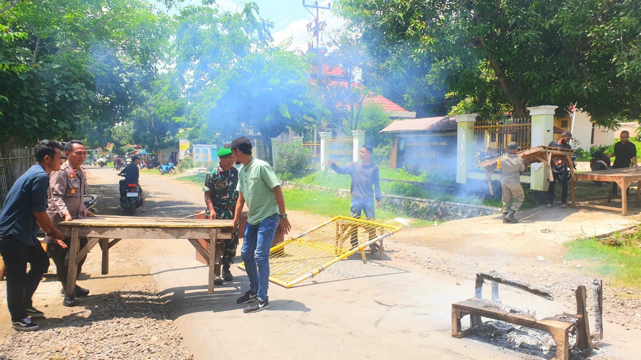 BLOKADE JALAN: Pemuda Kecamatan Madapangga memblokade jalan usai menyegel kantor camat setempat, Selasa (31/12).