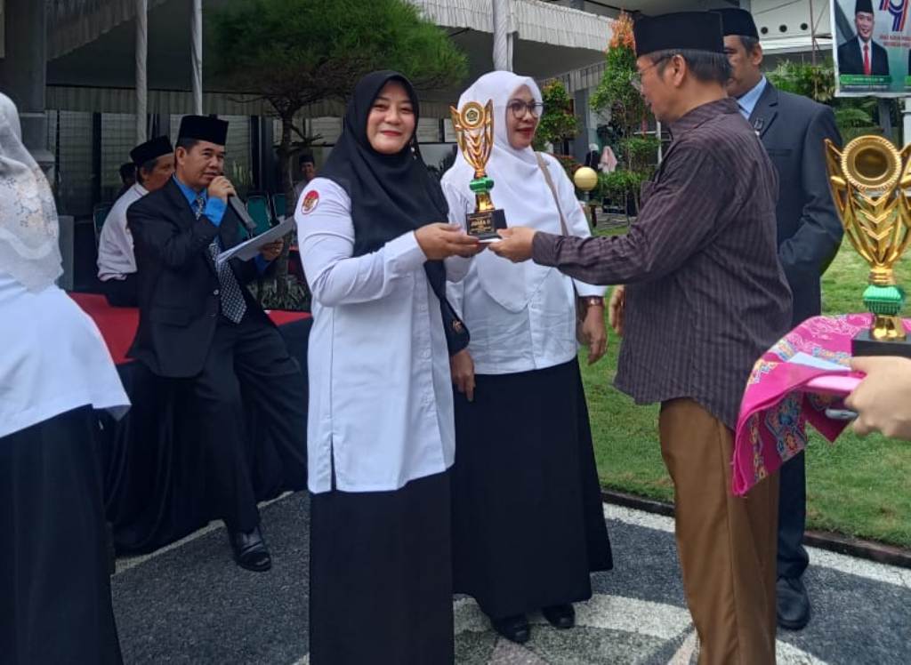 PENGHARGAAN: Kepala Kemenag Lobar H Hariadi Iskandar memberikan penghargaan pada peringatan HAB Kementerian Agama ke-79 di halaman Kemenag Lobar, Jumat (3/1) lalu.