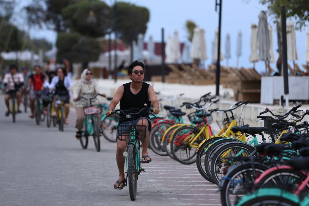 DESTINASI UNGGULAN: Bersepeda menjadi salah satu pilihan terbaik yang biasanya dilakukan oleh wisatawan lokal maupun mancanegara, saat menikmati keindahan pantai Gili Trawangan, Lombok Utara.