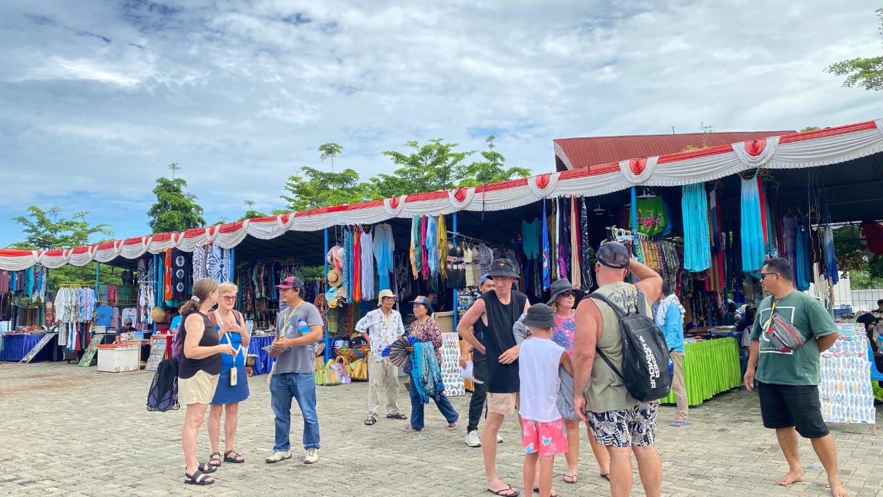 Beberapa wisatawan mancanegara yang dibawa kapal pesiar sedang melihat barang dari UMKM yang ada di Pelabuhan Gili Mas Lembar, awal tahun 2025.