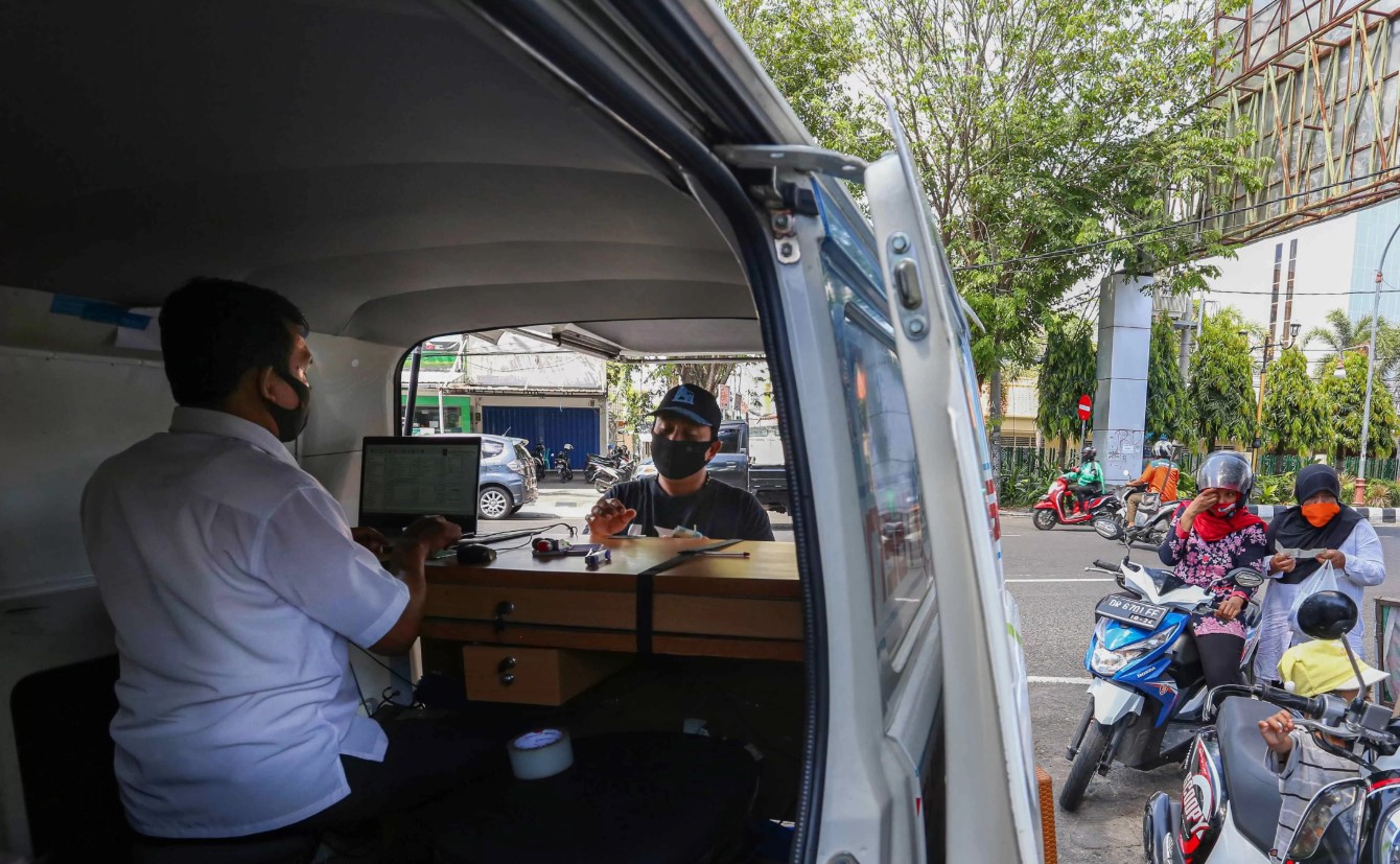 TAAT PAJAK: Seorang petugas penarikan PKB-BBNKB melayani masyarakat yang membayar pajak di depan Kantor Lurah Cakra Barat, beberapa waktu lalu.