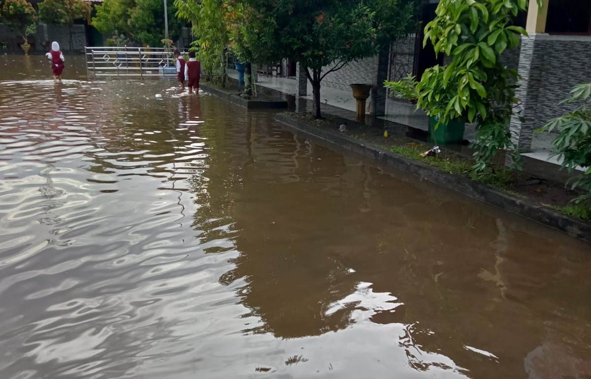 LANGGANAN BANJIR: Murid SDN 26 Cakranegara terpaksa buka sepatu ke sekolah karena banjir, belum lama ini.