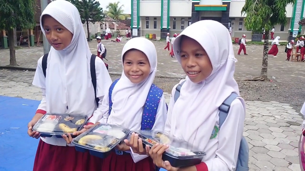 TUNGGU JUKLAK JUKNIS: Sejumlah murid membawa pulang paket makanan bergizi gratis yang diterimanya usai kegiatan Simulasi Makan Bergizi Gratis di MIN 1 Loteng, Praya, beberapa waktu lalu.