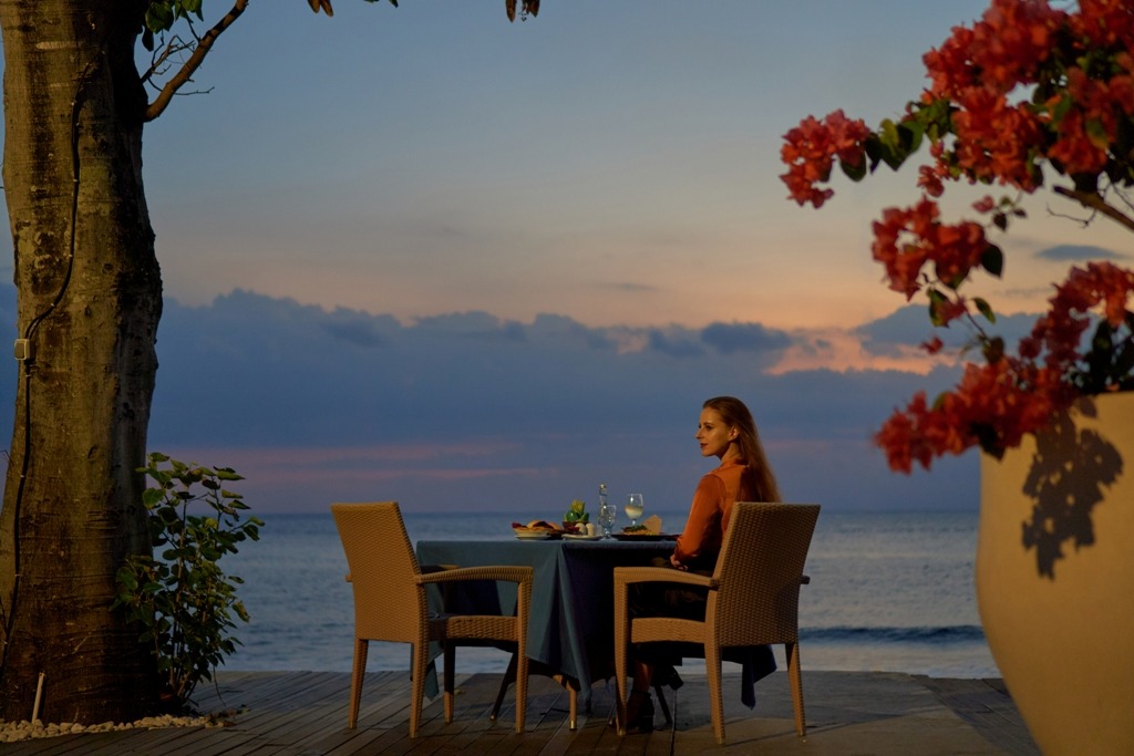 NIKMATI: Seorang tamu menikmati momen matahari terbenam di Holiday Resort Lombok, beberapa waktu lalu.
