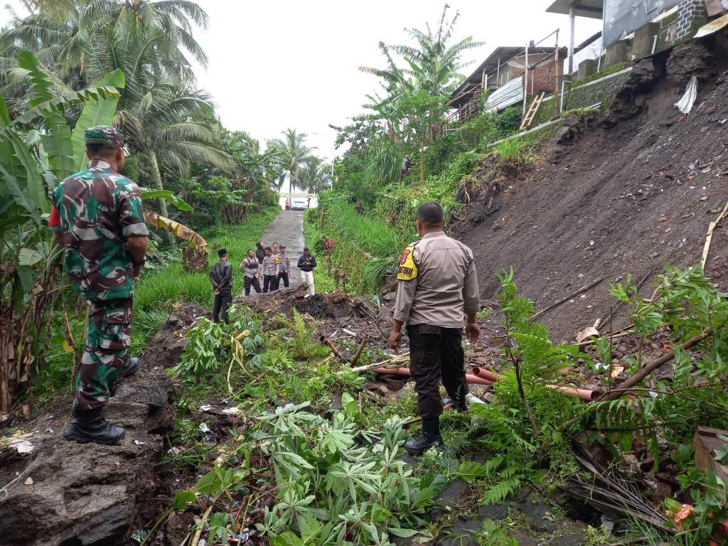 TINJAU: Bhabinkantibmas dan Babinsa Kembang Kuning saat mengecek kondisi longsor yang terjadi di Dusun Kembang Mekar, Desa Kembang Kuning, Kecamatan Sikur.