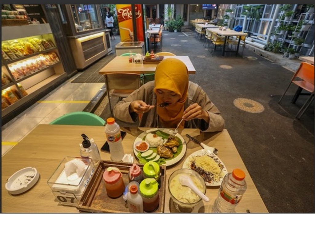 MENIKMATI HIDANGAN: Seorang warga sedang makan di salah satu kafe di Kota Mataram beberapa waktu lalu.&nbsp;