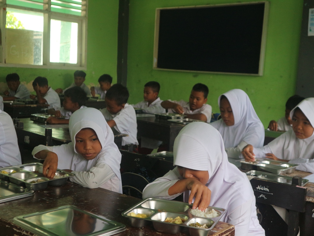 MAKAN: Siswa SDN 1 Keselet menikmati makanan yang disajikan dalam program Makan Bergizi Gratis hari pertama, Senin (13/1).