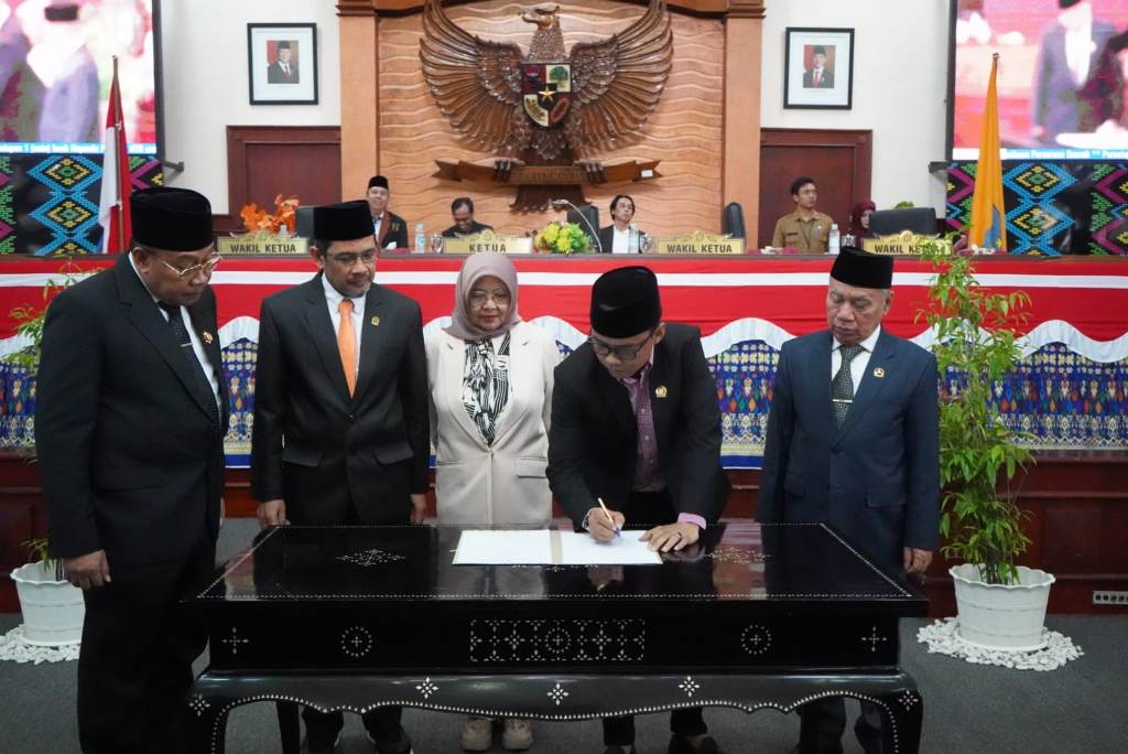 PENGESAHAN: Pimpinan DPRD NTB menandatangani Peraturan Daerah (Perda) penyertaan modal pemerintah daerah PT Jamkrida NTB dan PT BPR NTB, di ruang rapat paripurna DPRD NTB, Selasa (14/1).