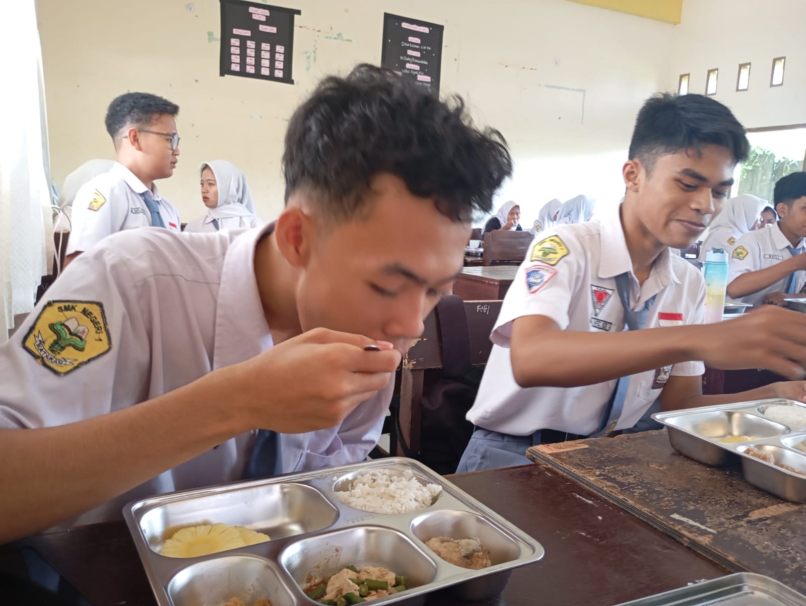 BANTU SISWA MISKIN: Siswa SMKN 1 Mataram menyantap makanan pada program MBG hari pertama di sekolah setempat, Selasa (14/1) lalu.