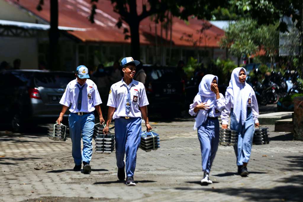 MAKAN BERGIZI GRATIS: Beberapa siswa Sekolah Menengah Atas (SMA/SMK) tengah membawa makanan saat uji coba Makan Bergizi Gratis di salah satu SMK di Kota Mataram, beberapa waktu lalu.