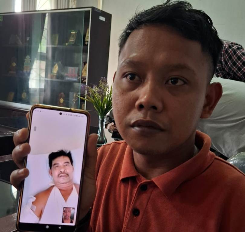 MINTA BANTUAN: Tantowi Jauhari menunjukkan foto ayahnya, Leman, 41 tahun, yang menjadi korban pembacokan di Pahang, Malaysia.