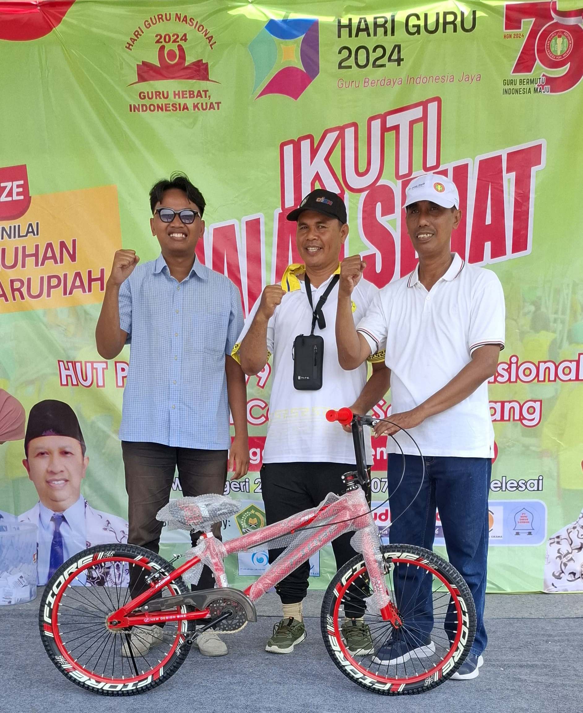 BERTARUNG: Ketua PGRI Cabang Selaparang Achmad Jauhari (kanan) memberikan doorprize pada gerak jalan sehat diadakan PGRI Kecamatan Selaparang, tahun lalu.