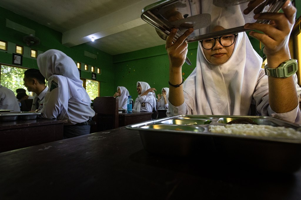 BUTUH PENANGANAN: Seorang siswa siap menyantap MBG saat uji coba di SMKN 1 Mataram awal pekan ini. Adapun sisa makanan karena tak dihabiskan siswa mesti menjadi perhatian.
