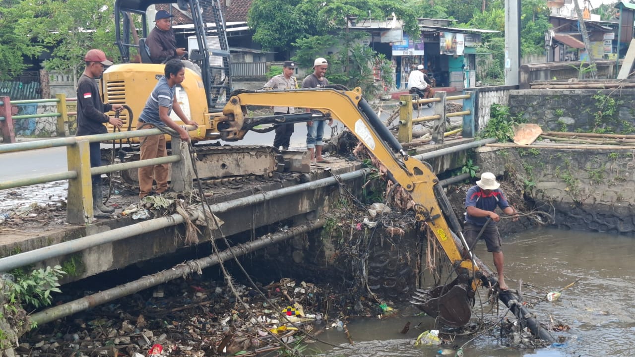 TERLALU RENDAH: Konstruksi Jembatan Dasan Geres, Gerung, terlihat terlalu rendah dari dasar sungai. Tampak petugas DLH mengangkut sampah dari badan sungai agar air tidak meluap ke ba