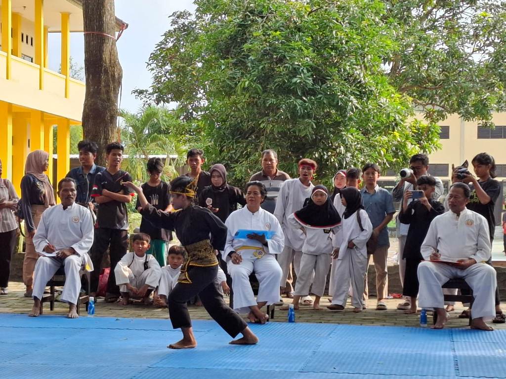 TAMPIL: Seorang peserta tampil pada kejuaraan pencak silat kategori seni tunggal di SMKN 1 Mataram, Jumat (17/1).