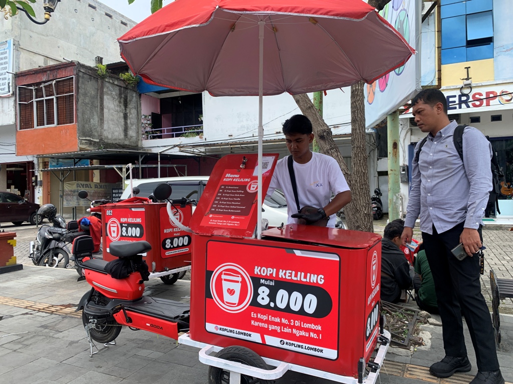 BELI KOPI: Seorang penjual kopi keliling melayani pembelinya di wilayah Cakranegara, beberapa waktu lalu.&nbsp;