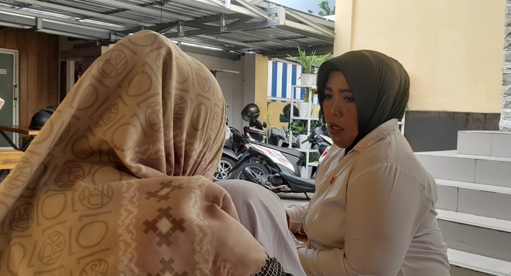 MELAPOR: LH, ibu dari murid salah satu murid SD swasta berbasis agama di Mataram (membelakangi kamera) saat melapor ke Polresta Mataram, Senin (20/1).