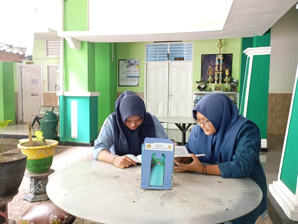 BACA BUKU: Dua siswa MAN 1 Mataram membaca buku di tempat yang disiapkan madrasah setempat, Kamis (23/1).